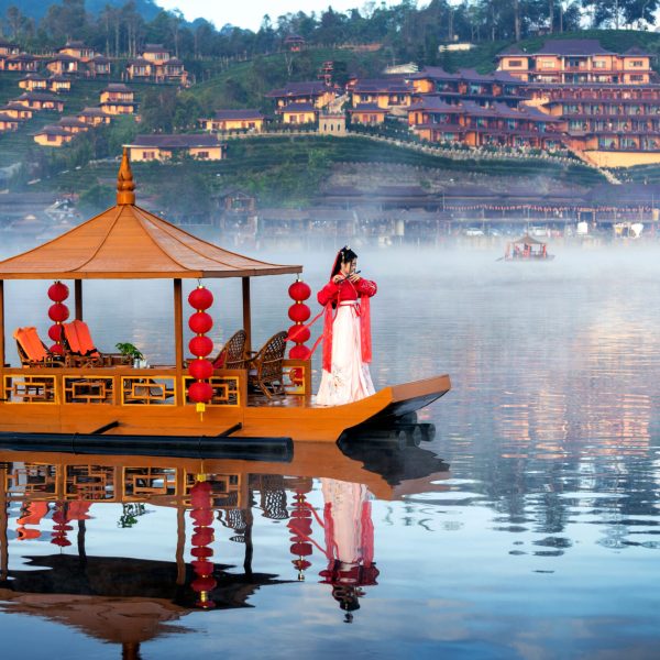 Asian woman wearing chinese traditional dress on a boat at Ban R Asian woman wearing chinese traditional dress on a boat at Ban Rak Thai village, Mae hong son province.